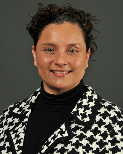 equity: Marcy L. Peake (headshot), founder of Center for Cultural Agility, smiling woman with short dark curly hair, black top, black houndstooth jacket