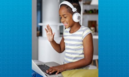 2020 children's mental health report; young black girl on laptop with headphones on smiling and waving