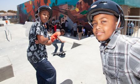 underserved community youth skatepark project grants; youth taking selfie at skatepark with friends in helmets