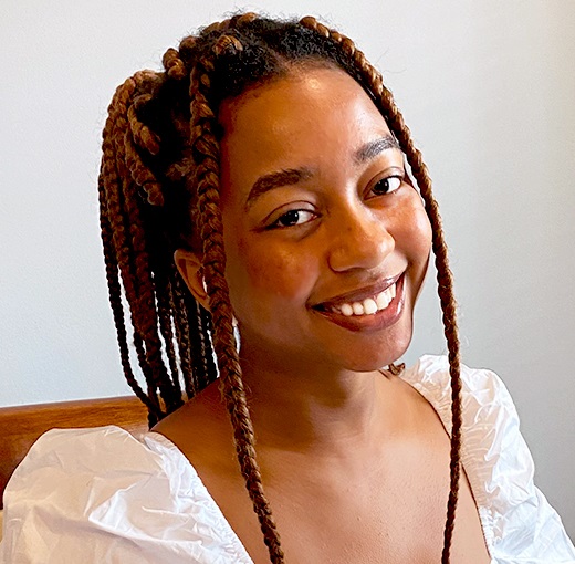 afterschool: T'Ajmal Hogue (headshot), teaching assistant, tutor with Girls' LEAP, smiling woman with red braids, white top