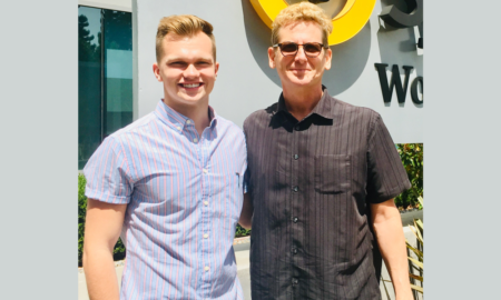 internships: 2 smiling blond young men with untucked short-sleeve shirts, jeans stand in front of building with Symantec World Headquarters sign