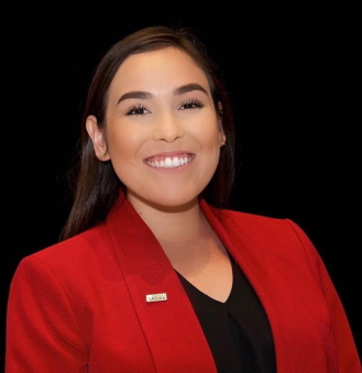 foster youth: Cristal Ramirez (headshot), youth coordinator for National Association of Counsel for Children, smiling woman with long brown hair, red jacket with pin on it, black top