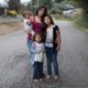 expanding broadband internet in disadvantaged southeast communities grants; young hispanic family standing in impoverished southern community street