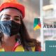 essential workers: Cover of report with masked woman wearing orange safety hat and earrings to left of type that says the state of working Alabama February 2021 Alabama Arise