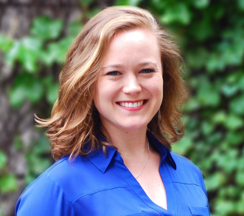 mission statement: smiling redhead wearing necklace, blue top