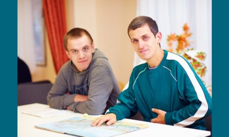 Better sex ed for youth with disabilities: cheerful adult men with disability sitting at the desk