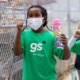 San Diego region summer learning: two young girls in green shirts and white facemasks happily running with water bottles