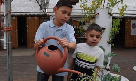Colorado youth of color and LGBTQ youth resiliency program grants: two young youth of color watering plants