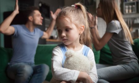 family violence prevention and services program grants: young, sad girl holding stuffed animal while parents fight