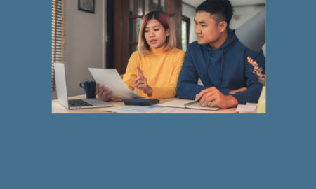 foster youth tax credit: Young Asian couple sit at table reviewing paperwork