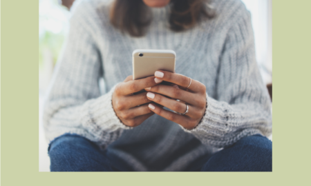 Texting teen health: young person in jeans and grey sweater sits holing phone texting