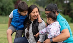 Western Native community COVID response grants: happy Native family hugging and talking outside