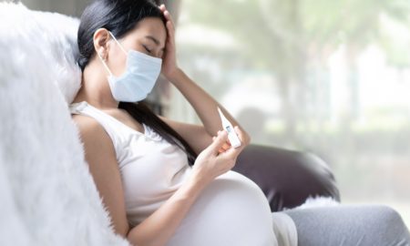 Maternal health inequities during COVID report: Asian pregnant woman is checking body temperature for symptom of fever, headache of viral infection, concept of sickness and healthcare in pregnancy in the situation of covid 19 outbreak.