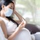 Maternal health inequities during COVID report: Asian pregnant woman is checking body temperature for symptom of fever, headache of viral infection, concept of sickness and healthcare in pregnancy in the situation of covid 19 outbreak.