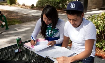 higher education racial equity grants: two ethnic students doing work outside on table