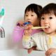 Illinois children's dental care access grants: two young Asian children brushing their teeth