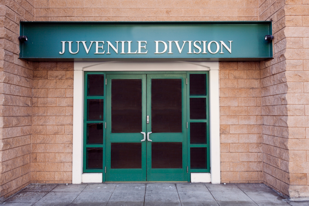 NY juvenile crime law: Green Double door entry to brick building with "Juvenile Division" sign above doors