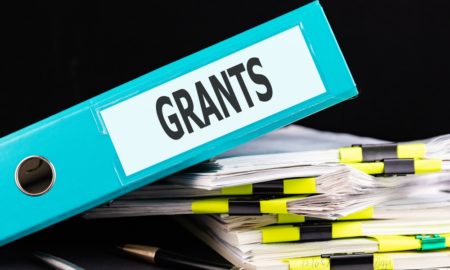 seeking grants with limited time and resources: graphic of stack of paper and binder with word "grants"