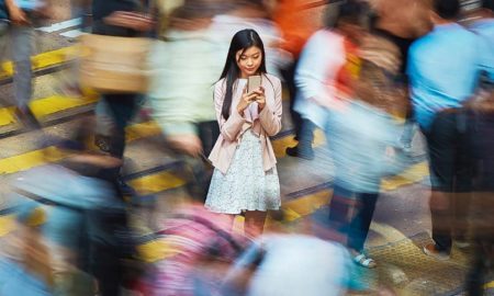 empowering the workforce of tomorrow report cover: young Asian woman on phone while crowds go by