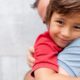 New England child health research grants: young, smiling boy being hugged