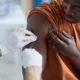Vaccine equity resource hub project grant: black male getting vaccine in clinic