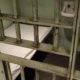 youth solitary confinement: closeup of jail cell door and interior with cot and metal toilet