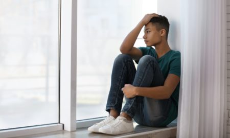Black LGBTQ+ youth report: upset teen of color looking out window
