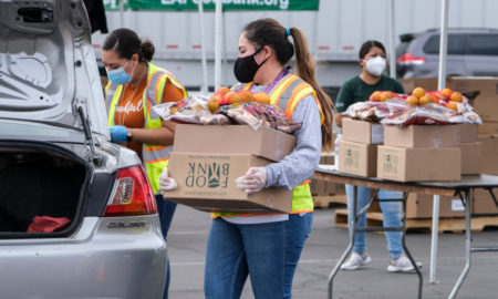NP Toolbox Donor communications: Three women in masks wearing work clothes load carboard boxes filled with food donations into vehicles