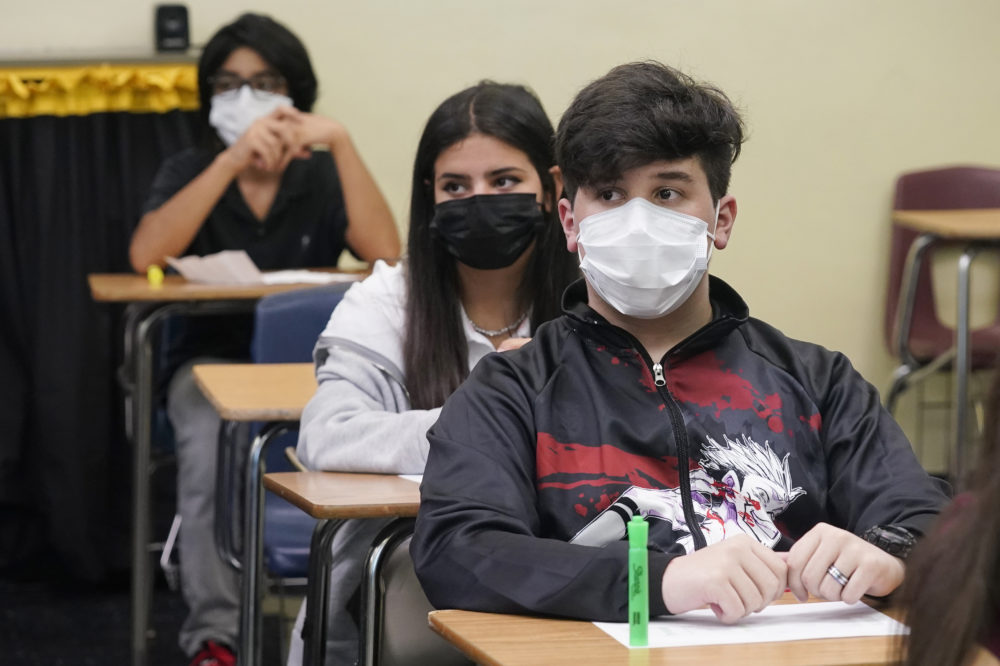 schools make few changes for new year: students in masks sitting at desks