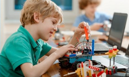 K-5 STEM education project grants; young student working on robot