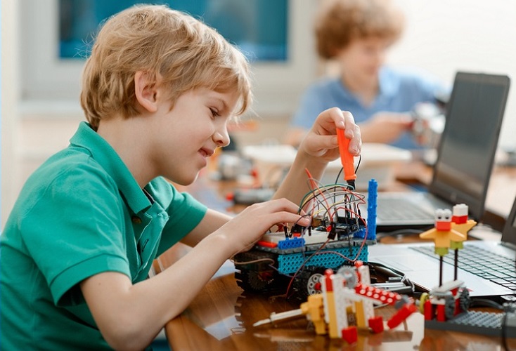 K-5 STEM education grant; young student working on robot