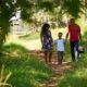 Urban parks and green spaces for minority communities grants: happy black family walking in park