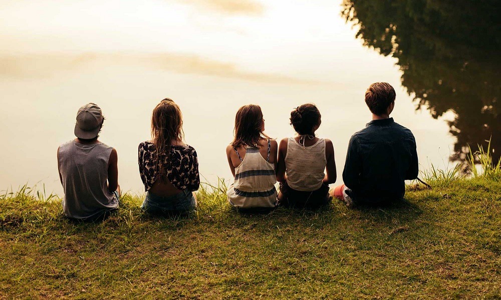 youth-led community project grants: group of youths sit and look at lake