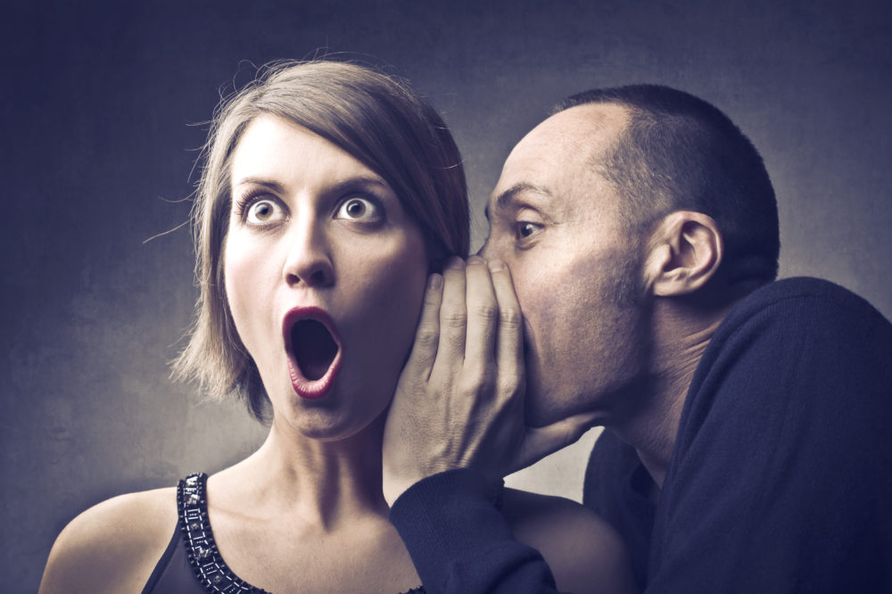 fundraising secret: man whispers into the ear of woman with shocked expression on her face