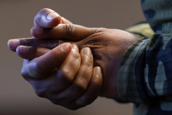Police excessive force children: Close-up of pair of Black adult hands holding each other tightly