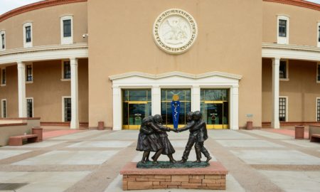 Child abuse New Mexico called into question: photo of New Mexico State Capitol with bronze statue of kids playing in front