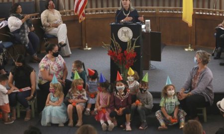 New Mexico child care grants: Woman governor at press conference with children on steps in front