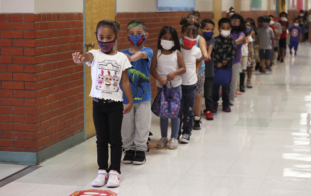 Education funding New Mexico elections: young school students lining up in school hallway