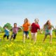 North and South Carolina child and family grants: group of young children running in field of yellow flowers