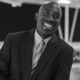 Daniel Shoy Jr newsmaker headshot: smiling bald black man in suit and tie