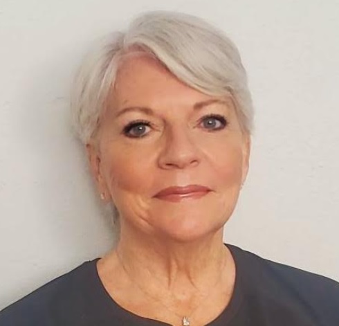 Laurie VanderPloeg headshot: white woman with short white hair on white background