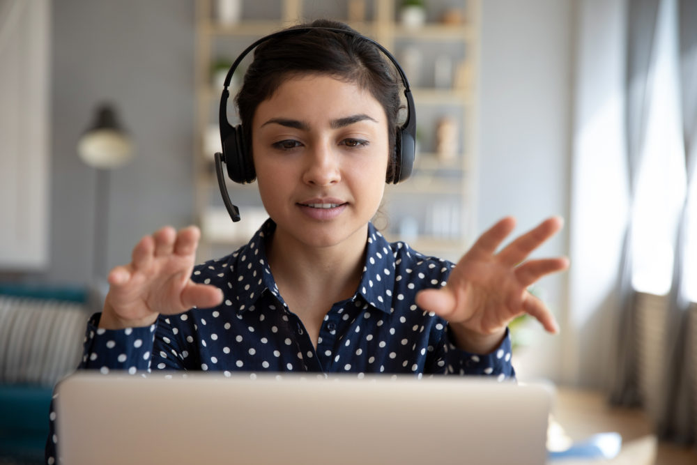 5 questions to ask when hiring consultant: young woman with headset talking on computer