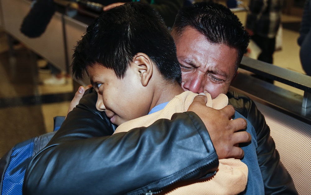 families separated at border now fear extortion: father hugging his young son tightly at reunification