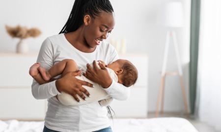 infant mortality racial disparity grants: happy black mother and baby in white room