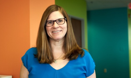 Lauren rush new director of education at Lilly Endowment: brown-haired woman with glasses smiling in office setting