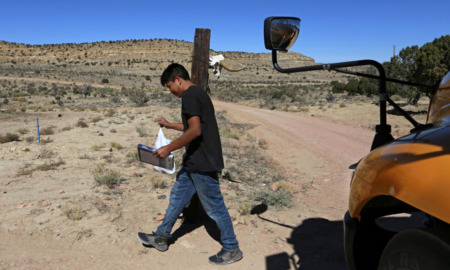 New Mexico Starlink internet: Teen bot walks away from schoolbus at the side of a dirt road.