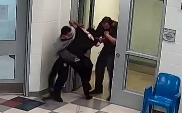 video shows foster teen death in custody: screenshot from surveillance video showing three figures in struggle