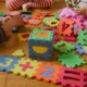 childcare grants: children playing with educational puzzle toys on floor