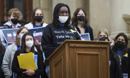 Oxford student seeks gun reform: young black girl with facemask on speaking at podium