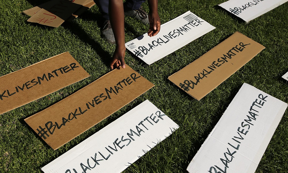 Trayvon Martin 10 Years Later: Black Lives Matter signs being picked up from grass